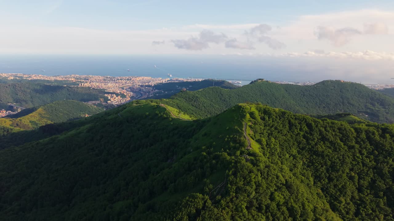 Lush mountains overlooking the sea and city, shot in italy, aerial view