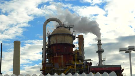 a smoke stack spews out pollution created by an oil refinery in utah