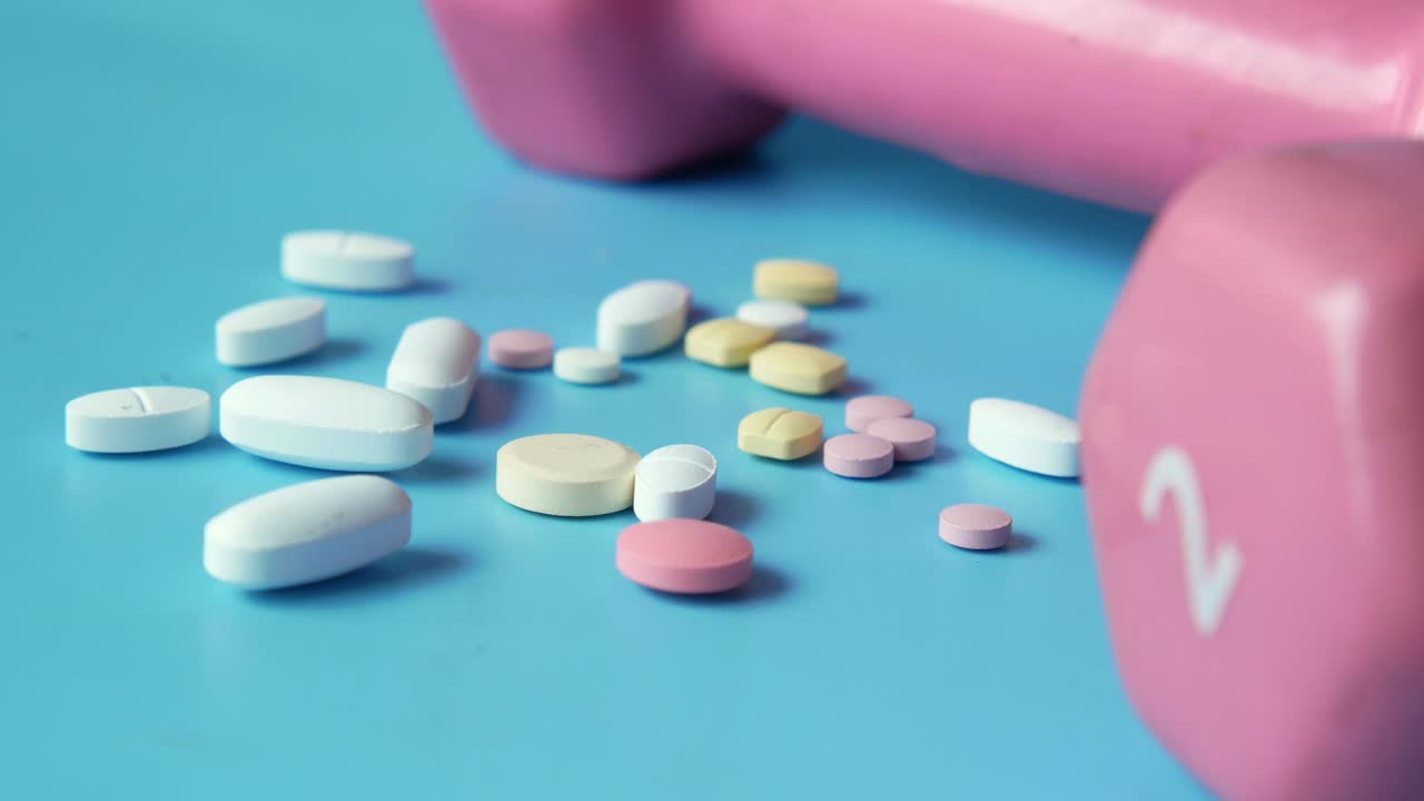 분홍색 덤벨과 다양한 약