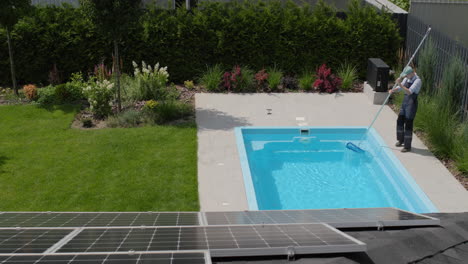un trabajador elimina los escombros de una piscina con una red. vista desde arriba