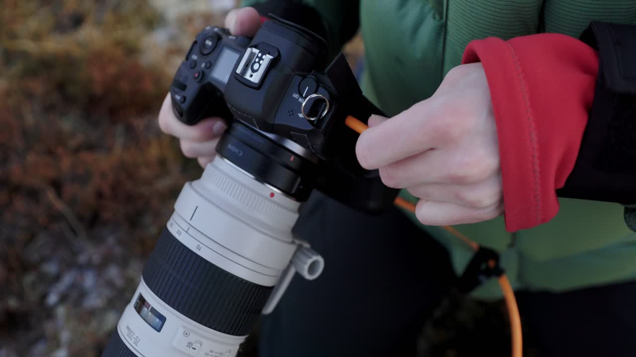 фотограф подключает оранжевый кабель usb-c к камере для фотосъемки на привязи