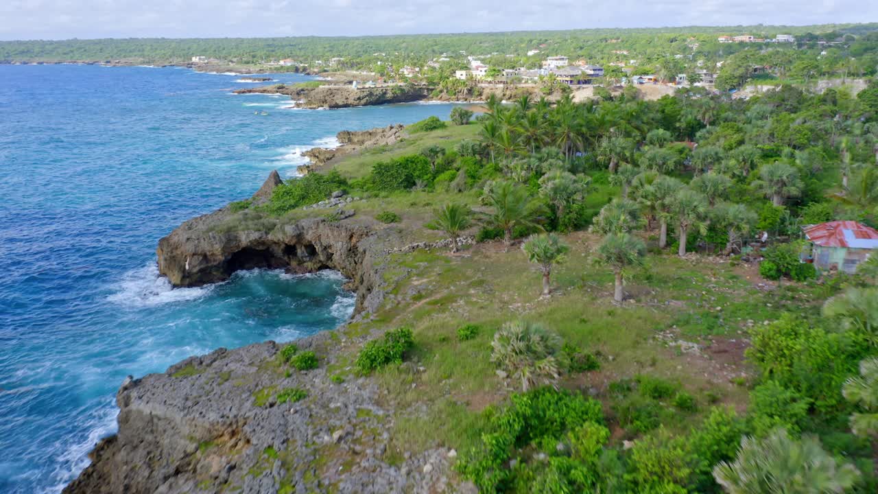 Vista drone che sorvola la costa tropicale frastagliata verso la città e il porto di Boca De Yuma, Repubblica Dominicana