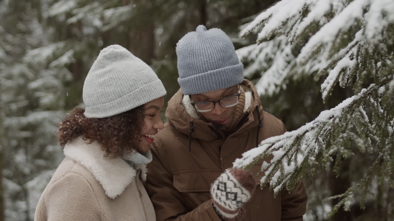 Couple profitant d'une journée enneigée en forêt