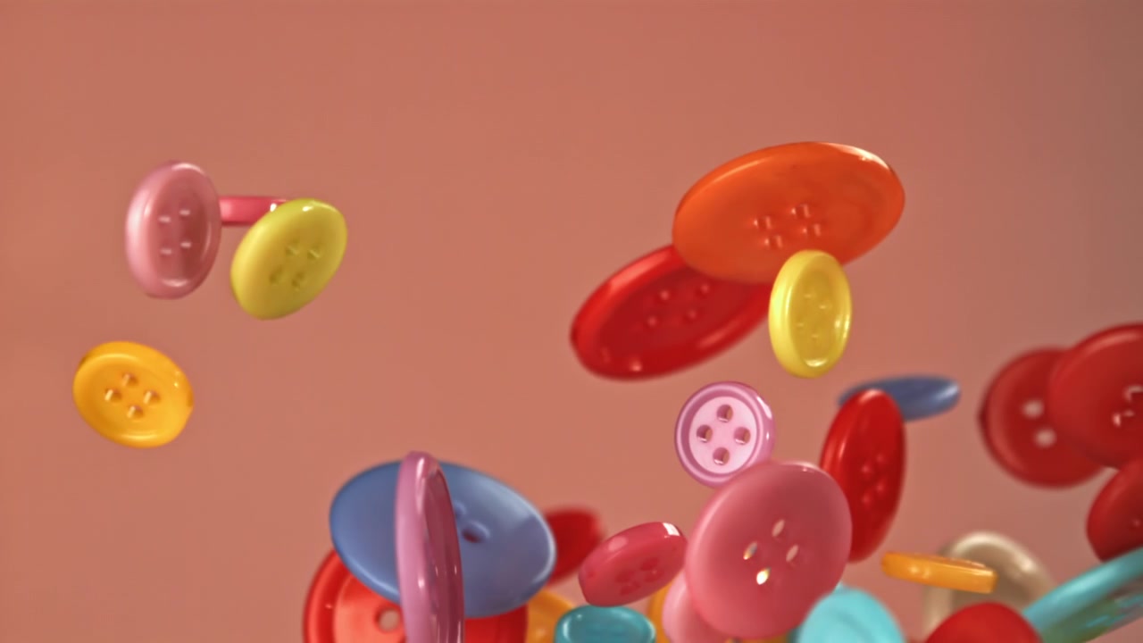Bottoni vivaci e colorati che fluttuano e cadono al rallentatore.