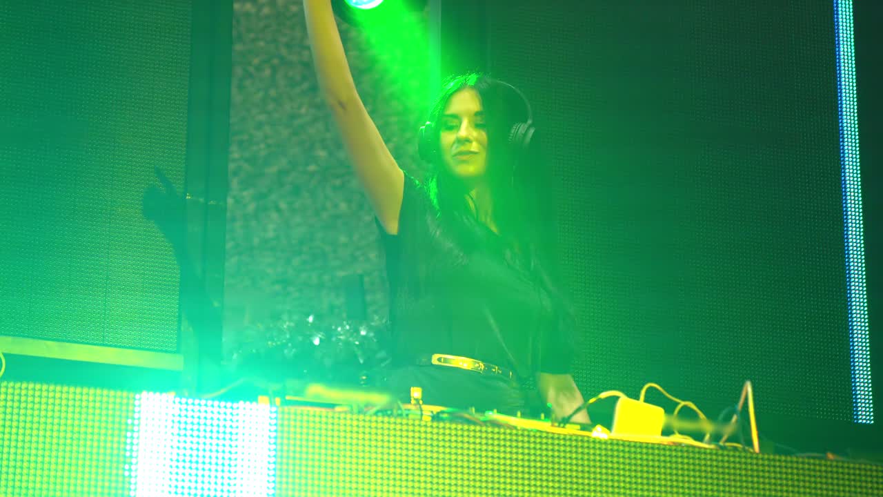 dj en el escenario en un club nocturno de disco mezclando el ritmo de la música techno