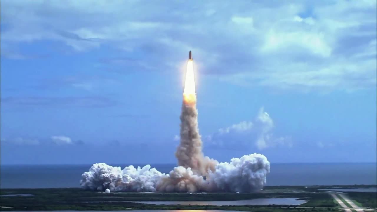 View of a space shuttle launching from a coastal location.
