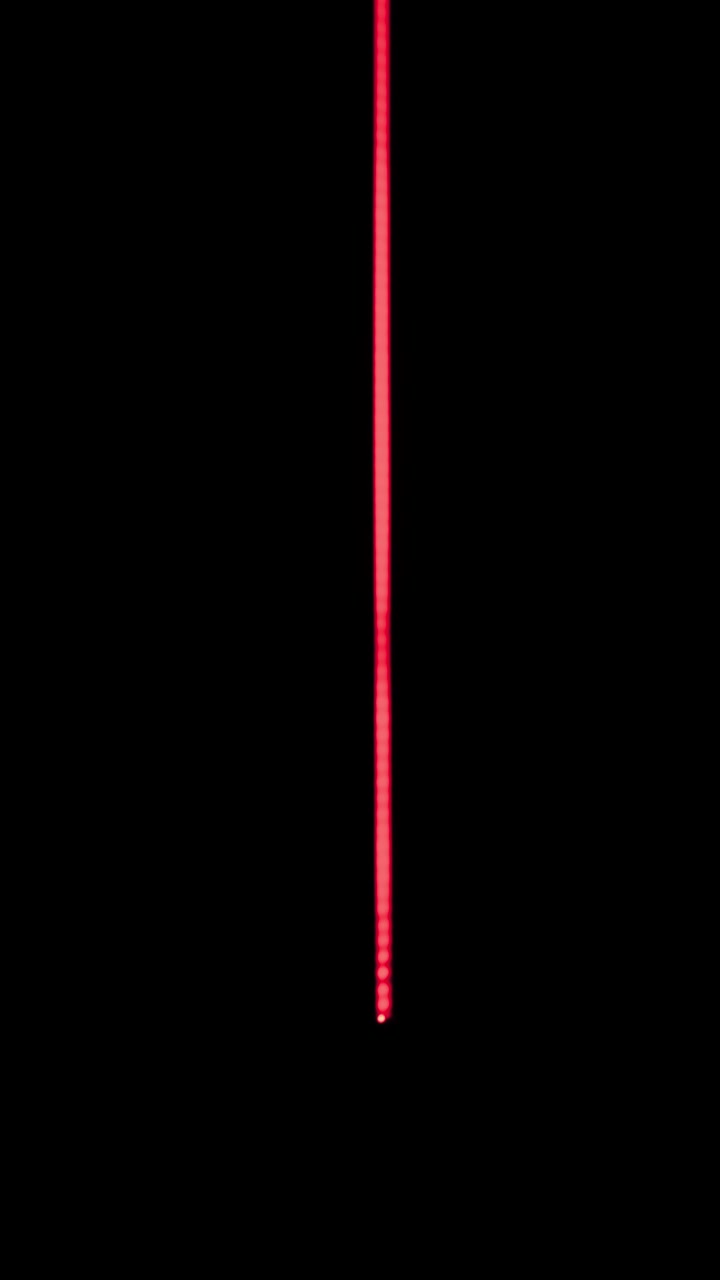 Flussi di luce rossa al neon verticali scendono a cascata attraverso uno spazio corridoio futuristico e buio. L'estetica cyberpunk minimalista con elementi lineari luminosi crea un'atmosfera digitale suggestiva