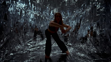 female dancer performing expressive modern choreography in metallic room