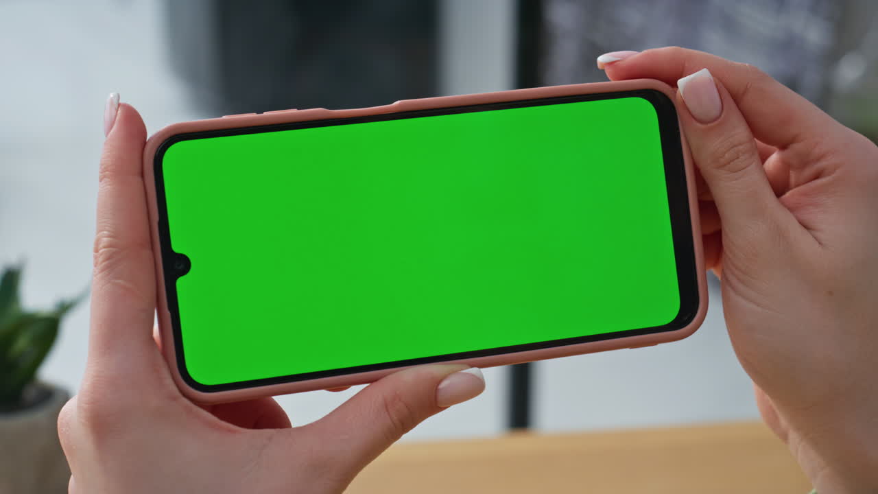 Company professional holding chroma key horizontal cellphone at office closeup