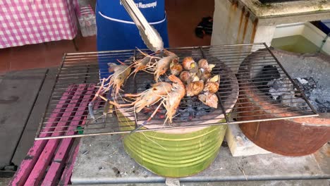 sequential grilling of shrimp over open charcoal fire