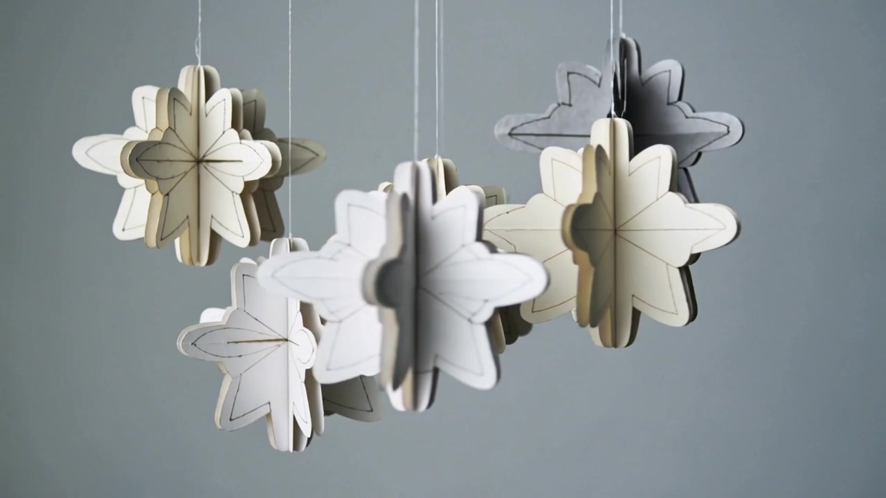 Rotating paper star mobile after soft draft, swaying in studio with thin cords showing pencil lines