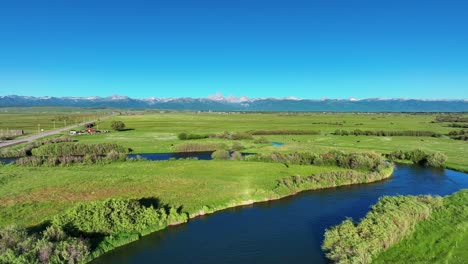 scenic green fields and river in saint anthony, idaho, united states - aerial drone shot