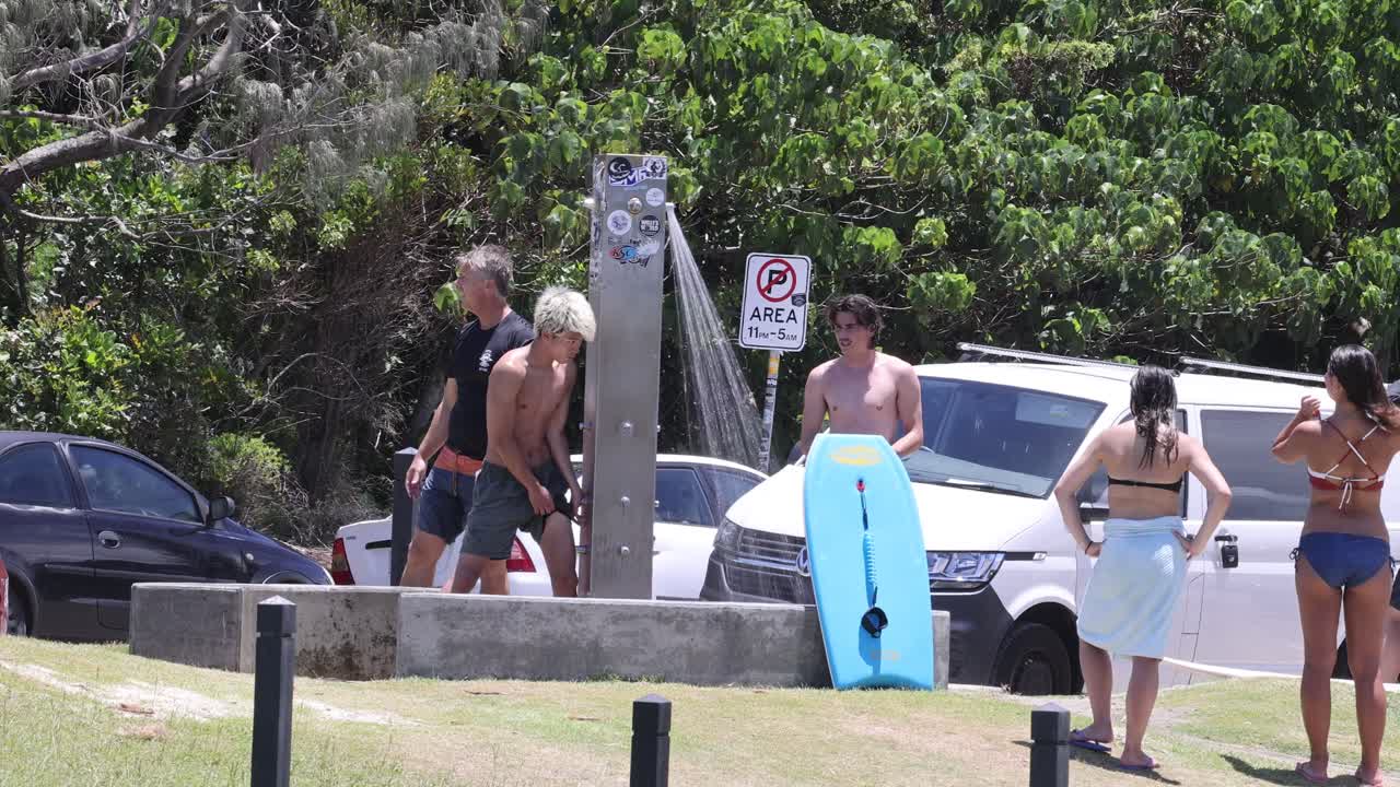 grupo de surfistas preparándose cerca de sus coches