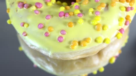 rotating donuts with different fillings on the mirror table. delicious sweet donut rotating on a plate. bright and colorful donut close-up macro shot spinning on a white background. seamless loop.