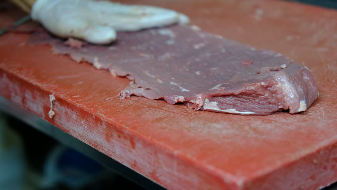 Cuts raw meat with knife close-up
