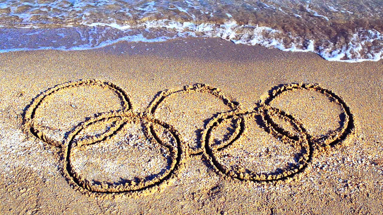Symbol Olympic game on sand, the beach. Inscription on sand