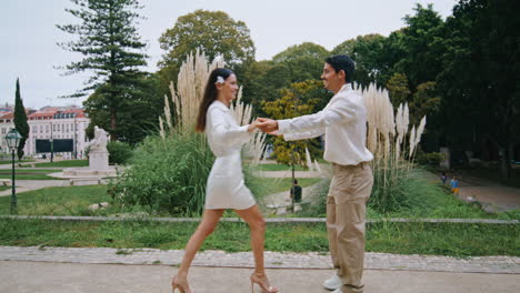 romantic sweethearts spinning at park. latina carefree couple embracing at date