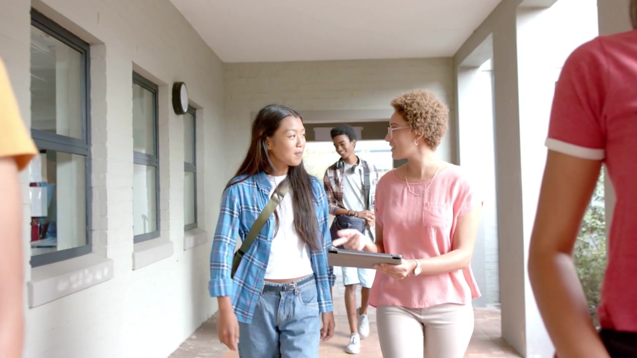 Two women leading students walking hall bar sliding over faces showing phone sub icons for channel
