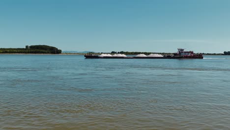 barcaza fluvial que transporta minerales blancos, en un gran río europeo, en un día claro y soleado