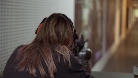 rare view of a woman with rifle in hands at shooting range with target