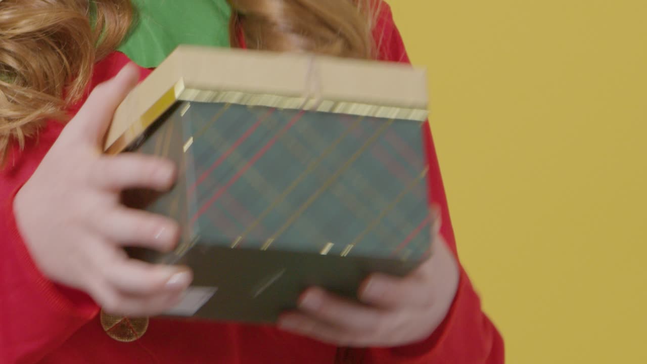 크리스마스 선물을 떨고 소녀를 닫습니다