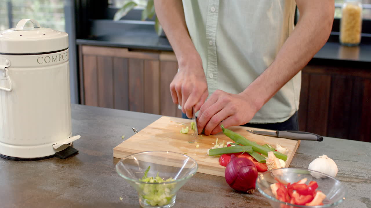 Chopping vegetables in kitchen, man preparing fresh ingredients for cooking