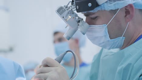 operation of removing tonsils under deep anesthesia, surgeon uses latest devices, cold plasma method, cuts swelling in throat, doctor works with new probe, medical headlamp, surgical loupes