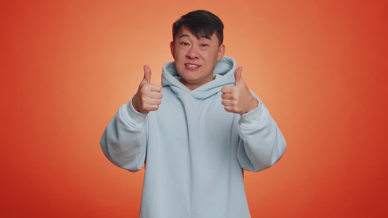 Asian business man showing thumbs up and nodding in approval successful good work nice great job