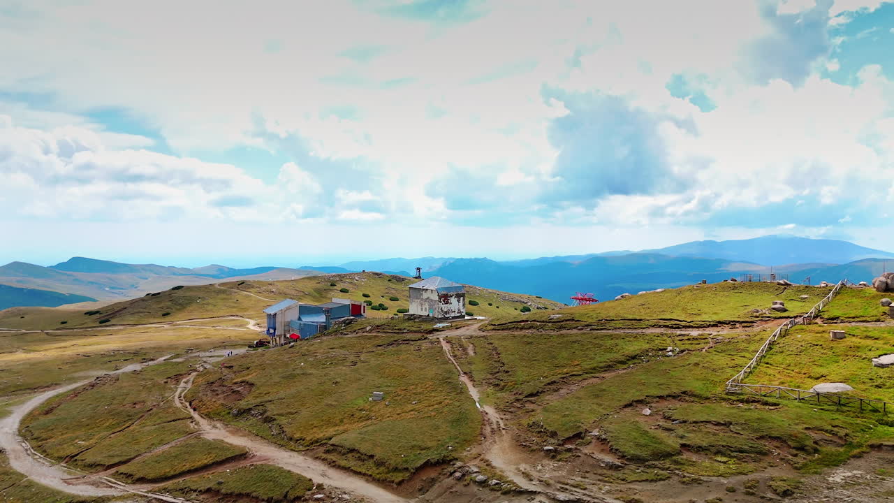 Cabins on Bucegi Plateau in Romania. Mountain cabins and trails on Bucegi Plateau under a bright sky