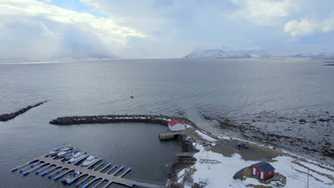 toma orbital de ariel del puerto de ase en noruega con impresionantes vistas de las montañas cubiertas de nieve y el muelle con barcos