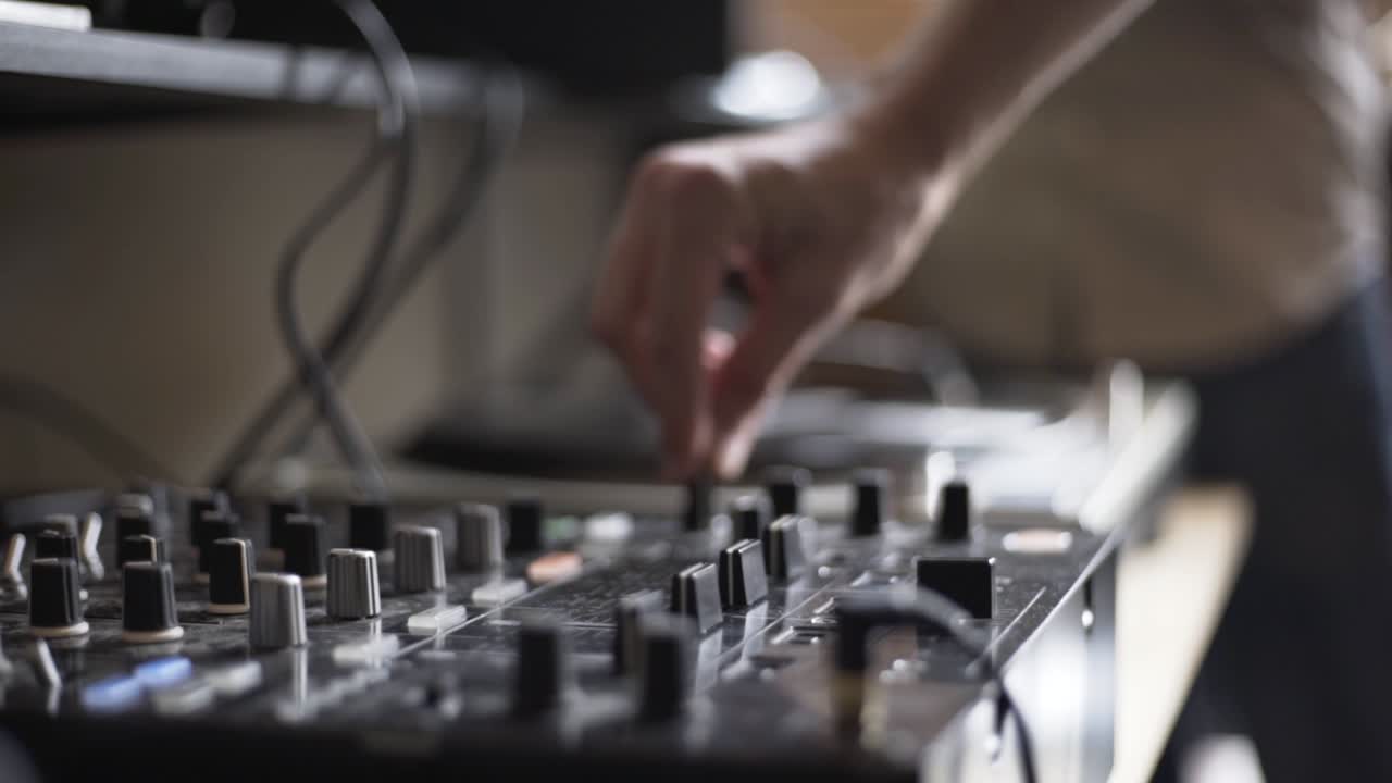 High Definition shot of DJ turning knobs on table
