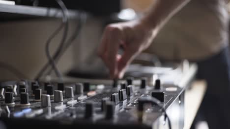 High-Definition-shot-of-DJ-turning-knobs-on-table