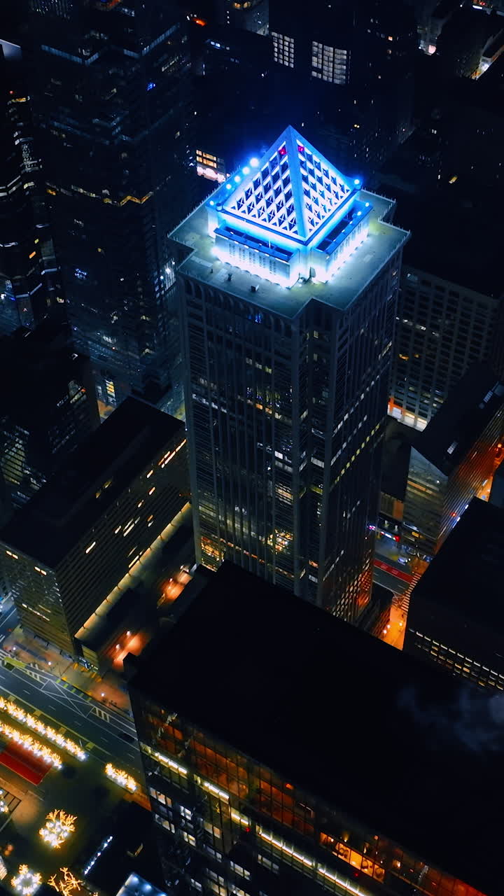 Highlighted top of BNY Mellon Center with white neon light. Distancing from the skyscraper of Philadelphia, Pennsylvania, USA at night. Vertical video