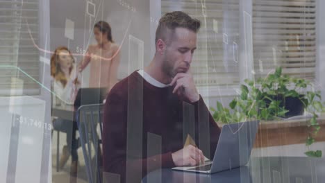 A-happy-caucasian-businessman-is-working-on-a-laptop-in-a-modern-office