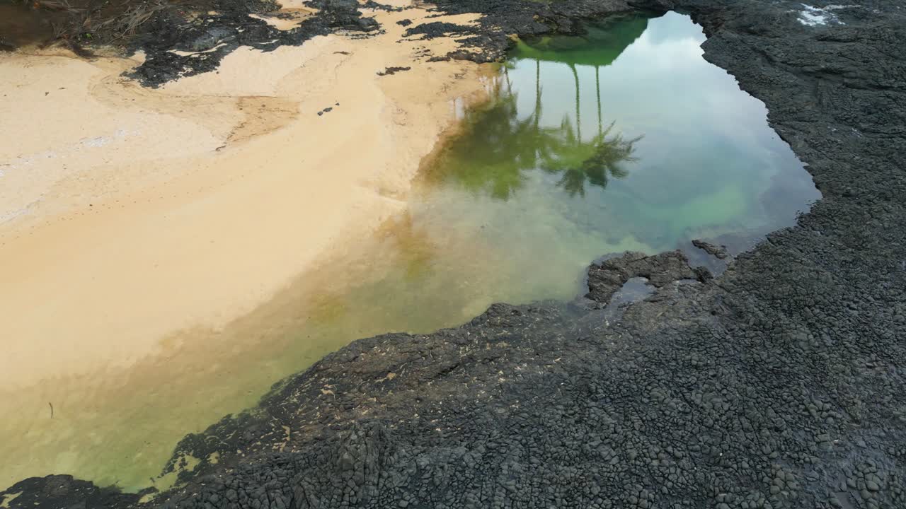 Vista aerea verso Praia Piscina dove si possono vedere le ombre delle palme sul mare. São Tomé, Africa