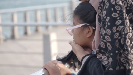 young girl and woman looking out together