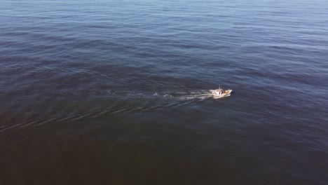 backward drone flight over a fishing boat on the uruguayan coast in the atlantic ocean