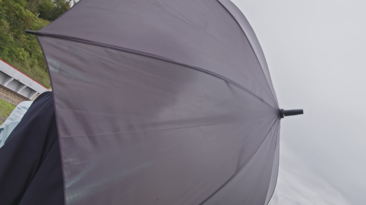 pareja caminando por la costa bajo la lluvia