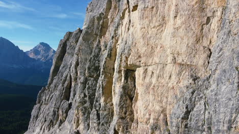 aerial of jagged rocks on side of dolomite mountain on sunny summer day