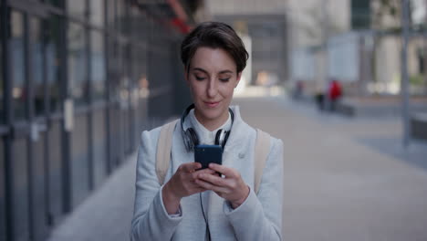 portrait young independent business woman using smartphone enjoying texting on mobile phone browsing messages online in urban city wearing stylish corporate fashion