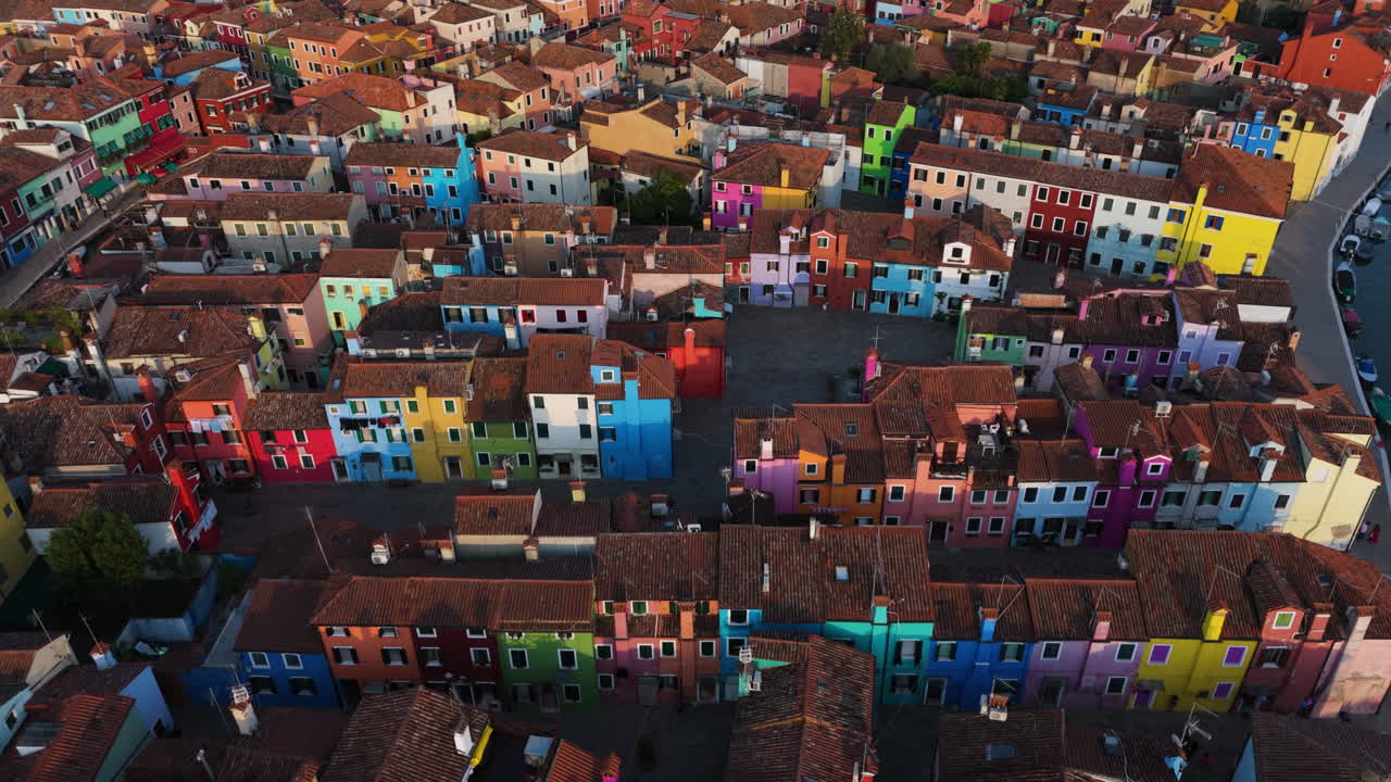Brightly Painted Facade Of Houses In Burano Island At Sunset In Venice, Italy. - aerial shot