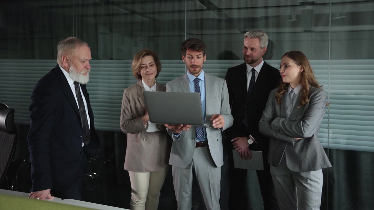 Diverse Business Team Discussing Project on Laptop in Modern Office