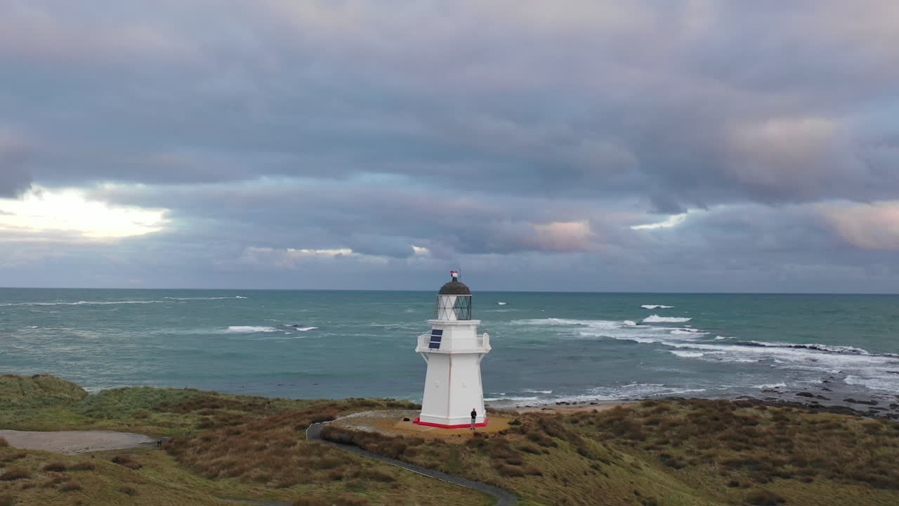 vista aérea de aviones no tripulados volando alrededor del faro de wapapa en la costa de nueva zelanda
