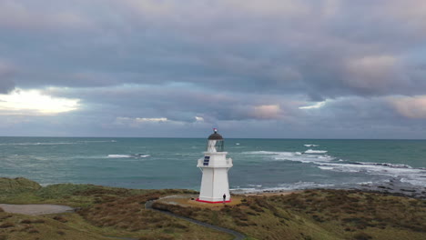 aerial drone view flying around waipapa lighthouse on the coast of new zealand