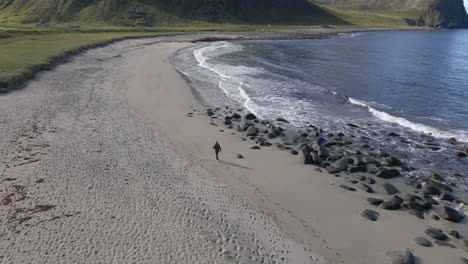 a person walking over a secluded beach in lofoten, norway