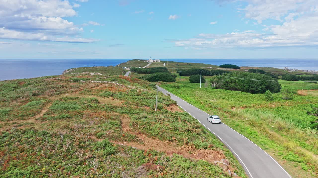 맑은 하늘을 가진 케이프의 외로운 해안 도로를 운전하는 한 대의 자동차
