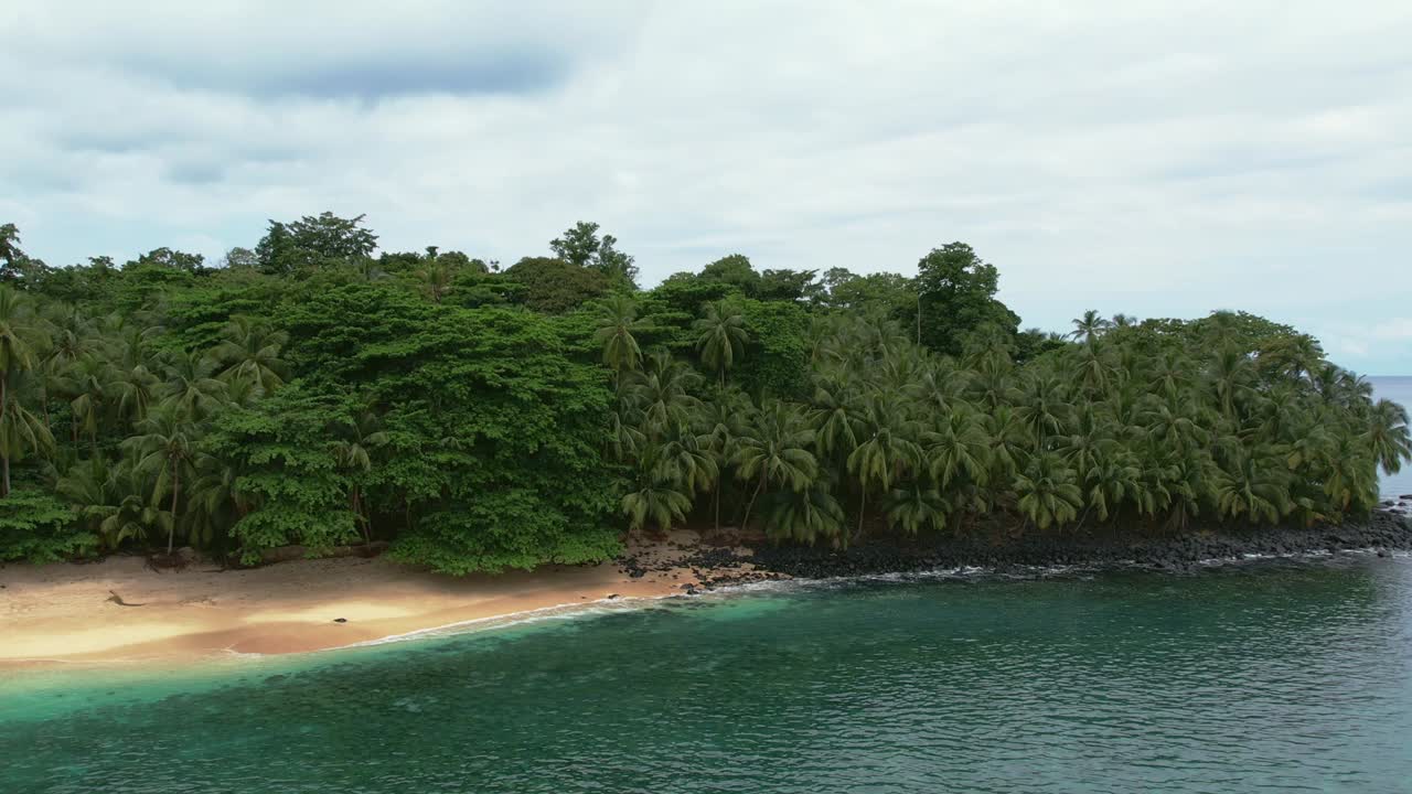 vista aérea de una playa de agua turquesa rodeada de exuberante selva tropical en la isla de príncipe