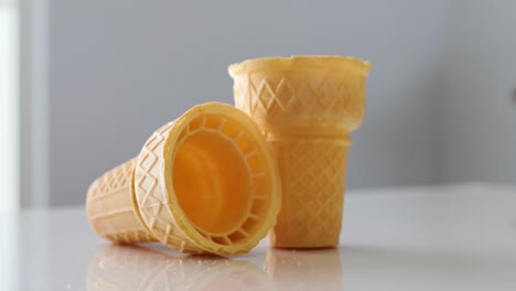 man picking up ice cream cone on a white table