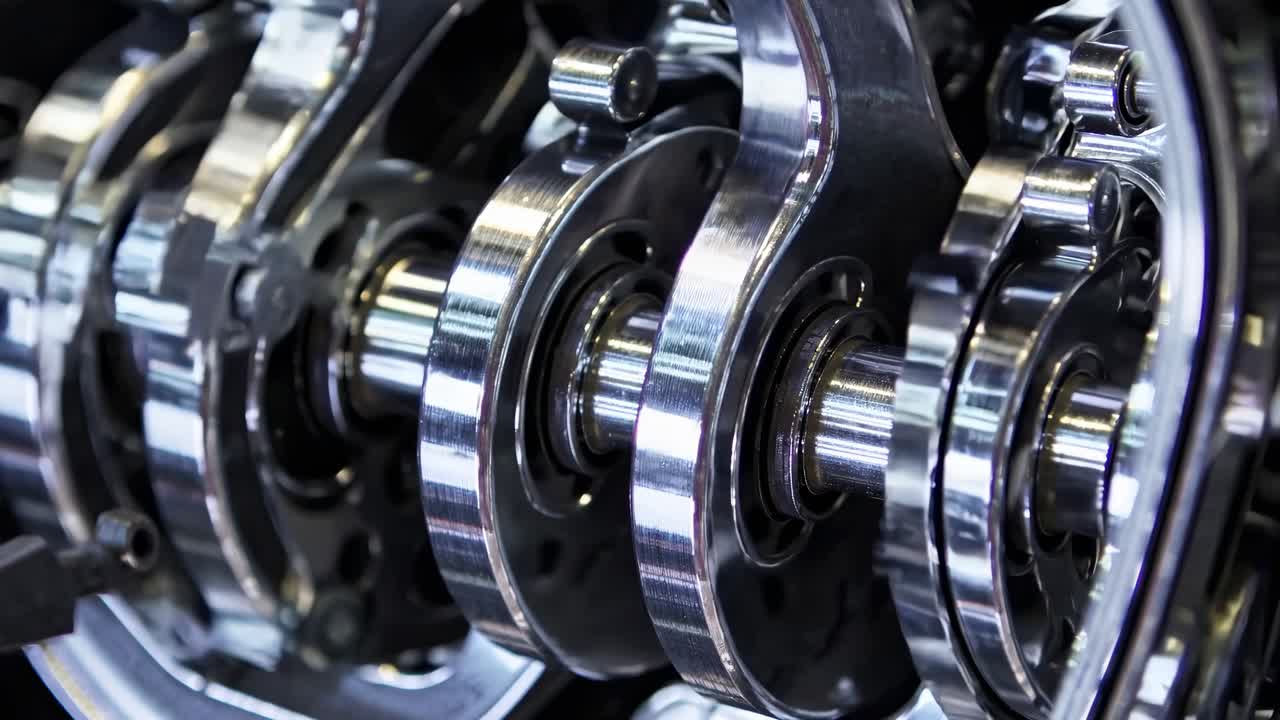 Close-up video of a shiny, intricate engine mechanism, showcasing gears and metal parts
