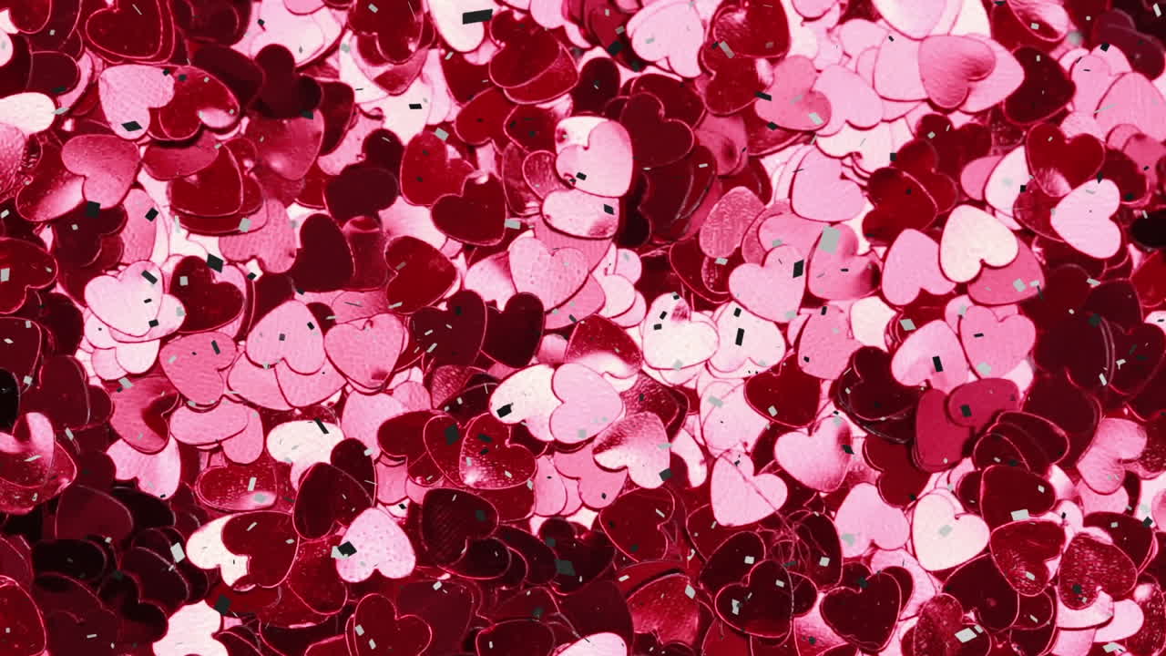 Animation of confetti falling on pink and red hearts